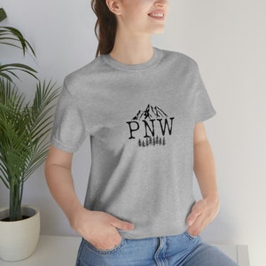 PNW Mountains and Trees.  BLACK lettering Unisex Jersey Short Sleeve Tee. Bella + Canvas