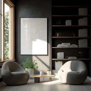 Peut inclure: Un intérieur de salon avec deux fauteuils gris, une table basse en bois et un grand tableau encadré au mur. La pièce dispose d'une bibliothèque avec des livres et des objets décoratifs. La lumière du soleil pénètre par une fenêtre.