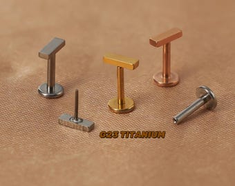 Puede incluir: Cuatro piezas de joyería corporal de titanio con un diseño de barra. La joyería está disponible en plata, oro y oro rosa. El texto "G23 Titanium" es visible en la imagen.