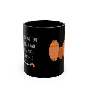 Peut inclure: Mug noir en céramique avec une citation en français en texte blanc et des illustrations de poteries marron. La tasse a une finition brillante et une anse standard.