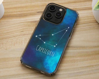 May include: A clear phone case with a blue and green galaxy design featuring the constellation Capricorn and the word "Capricorn" in white text.