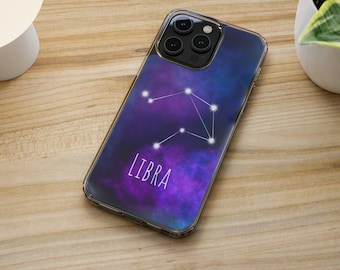 May include: A clear phone case with a galaxy-like design featuring the constellation Libra and the word "LIBRA" in white text.
