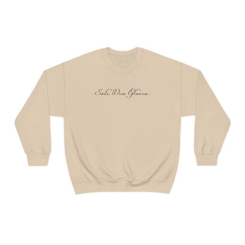May include: A beige sweatshirt with the text "Soli Deo Gloria" printed in black on the front.