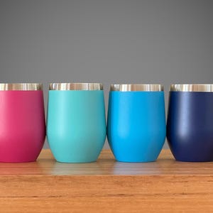 Puede incluir: Seis vasos de vino de acero inoxidable en varios colores, incluyendo rojo, rosa, turquesa, azul, azul marino y morado. Los vasos tienen un borde plateado y est&aacute;n forrados con acero inoxidable.