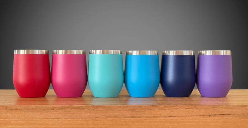 Puede incluir: Seis vasos de vino de acero inoxidable en varios colores, incluyendo rojo, rosa, turquesa, azul, azul marino y morado. Los vasos tienen un borde plateado y est&aacute;n forrados con acero inoxidable.