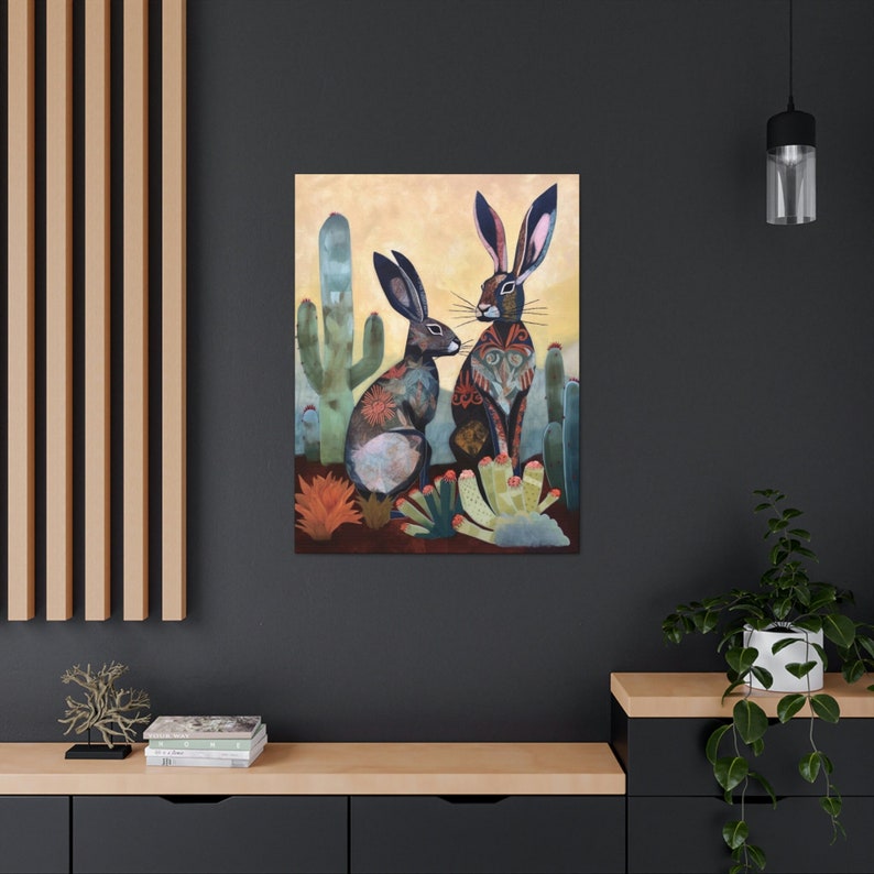May include: A painting depicting two black rabbits with intricate patterns, set against a desert landscape featuring cacti and flowers. The rabbits are gazing at one another.
