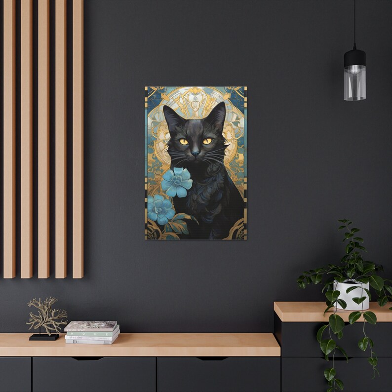 May include: A black cat with yellow eyes sits in a decorative frame with blue flowers. The frame is gold and has a geometric design.