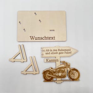 May include: Wooden motorcycle retirement sign with a personalized message, a sign that reads "Ab in den Ruhestand und allzeit gute Fahrt!" and the name "Karsten".