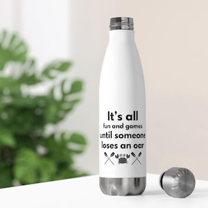 May include: White stainless steel water bottle with a black graphic that says "It's all fun and games until someone loses an oar" with a crab and two oars underneath the text.