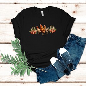 May include: Black t-shirt with a graphic of three chickens and strawberries. The chickens are brown and white with red combs. The strawberries are red and green.