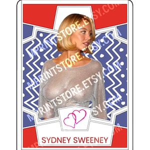 May include: A trading card featuring a woman with blonde hair wearing a silver mesh top. The card has a red and blue border with the text "SYDNEY SWEENEY" at the bottom. Two pink hearts are in the center.