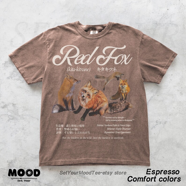 K&ouml;nnte beinhalten: Espressofarbenes T-Shirt mit einer Grafik von Rotf&uuml;chsen und dem Text "Red Fox" dar&uuml;ber. Das Shirt enth&auml;lt japanischen Text und zus&auml;tzlichen Text &uuml;ber den Lebensraum und das Verhalten des Fuchses. Teil der "Comfort Colors"-Kollektion.