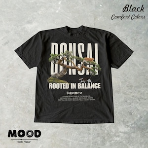 May include: Black t-shirt with a bonsai tree graphic and the text "BONSAI ROOTED IN BALANCE". The design includes a cat on the tree and Japanese text. The shirt also has the text "Black Comfort Colors" at the top.