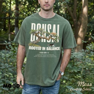 May include: Green t-shirt with a bonsai tree graphic and the text "BONSAI ROOTED IN BALANCE". The shirt also features Japanese text and the words "MOOD" and "Comfort Colors".