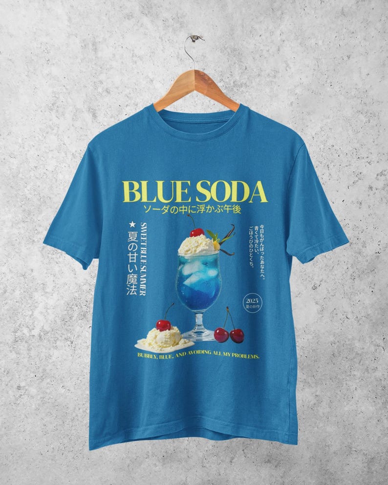May include: Blue t-shirt with a graphic of a blue soda drink with whipped cream and cherries. The text "BLUE SODA" and Japanese characters are printed in yellow. The phrase "BUBBLY, BLUE, AND AVOIDING ALL MY PROBLEMS" is printed at the bottom.