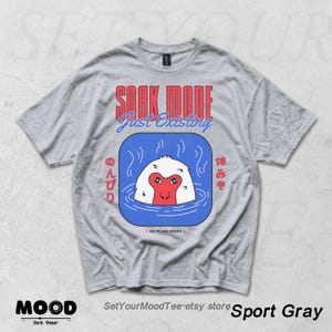 May include: Sport gray t-shirt with a graphic of a Japanese macaque soaking in a blue hot spring. The text "SOAK MODE Just Existing" is above the graphic. Japanese text is on either side of the graphic. The phrase "NO PLANS TODAY" is below the graphic.