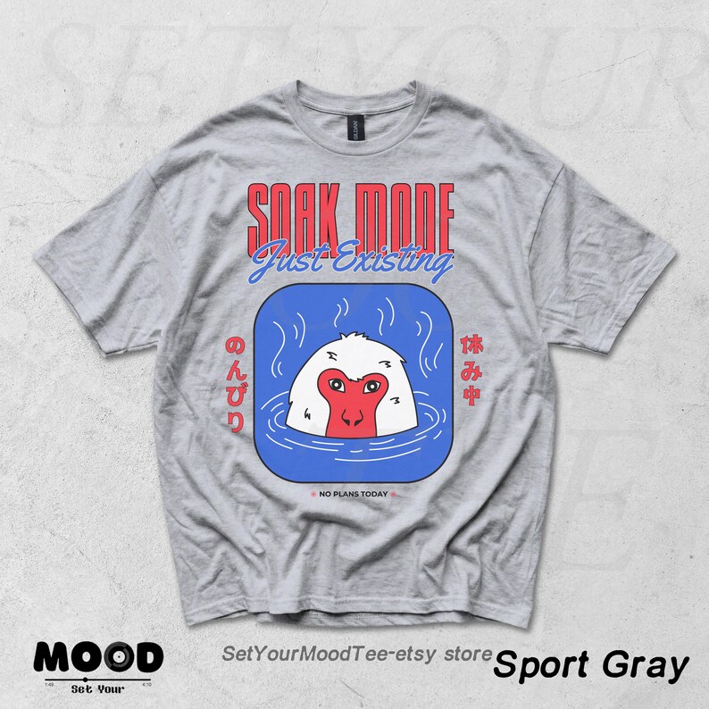 May include: Sport gray t-shirt with a graphic of a Japanese macaque soaking in a blue hot spring. The text "SOAK MODE Just Existing" is above the graphic. Japanese text is on either side of the graphic. The phrase "NO PLANS TODAY" is below the graphic.