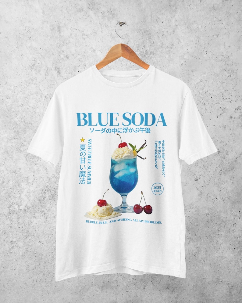 May include: White t-shirt with a blue graphic that says "BLUE SODA" in large letters. The graphic includes a blue drink with whipped cream, cherries, and text in Japanese. The text "SWEET BLUE SUMMER" is also present.