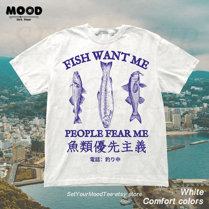 May include: White t-shirt with a blue graphic of three fish and the text "FISH WANT ME PEOPLE FEAR ME". Additional text in Japanese characters is also present. The shirt is labeled "Comfort colors".