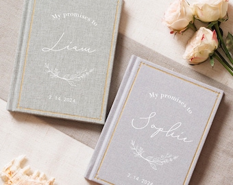 May include: Two light gray fabric-covered hardcover books with gold-stitched borders. Each cover features the white printed text "My promises to" above a name, "Liam" or "Sophie," and the date "2. 14. 2024" with a white floral line art graphic.