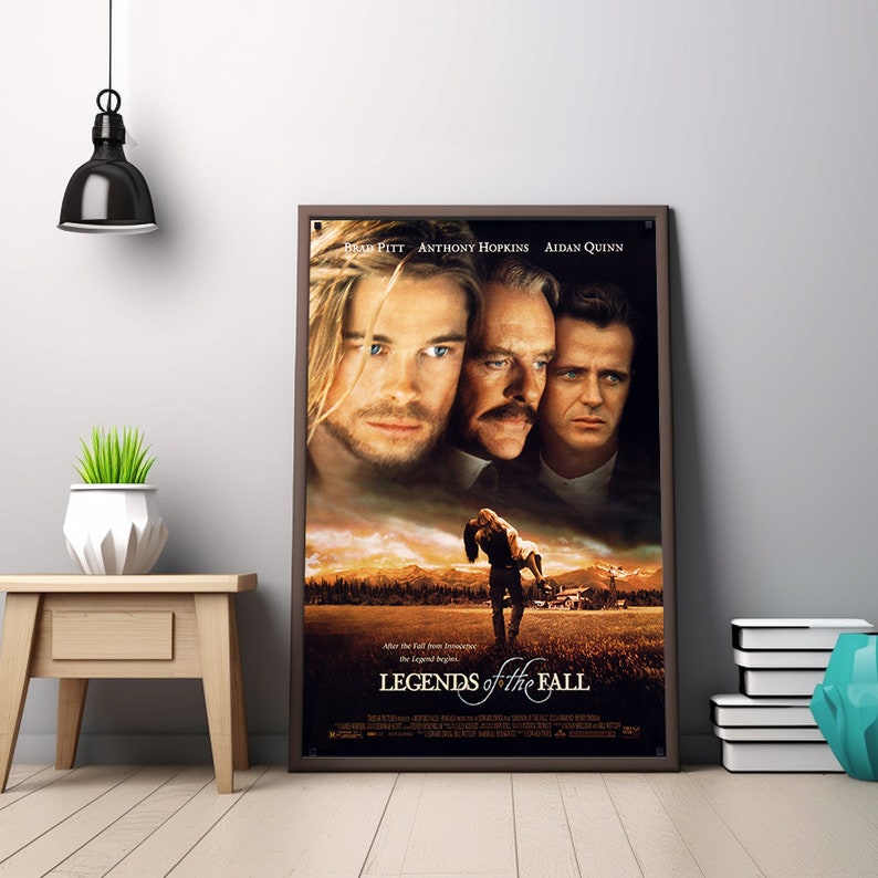 Op de afbeelding: Een ingelijste filmposter voor "Legends of the Fall" met Brad Pitt, Anthony Hopkins en Aidan Quinn. De poster heeft een donkerbruine lijst en wordt op een lichtgekleurde muur getoond. De titel van de poster staat onderaan.