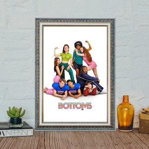 May include: A framed movie poster with a group of people wearing athletic uniforms and posing in front of a white background. The poster has the title "Bottoms" in large, colorful letters.