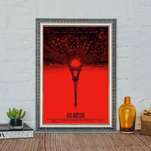 Może przedstawiać: Oprawiony plakat filmowy do filmu "As Above, So Below" z czerwonym tłem i Wieżą Eiffla. Plakat ma napis "The Only Way Out Is Down" u góry i "As Above So Below" na dole. Plakat jest w srebrnej ramie.