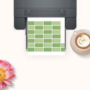 Puede incluir: Una impresora imprimiendo una carta de color con 25 tonos diferentes de verde. La carta est&aacute; etiquetada con los n&uacute;meros del 1 al 25.