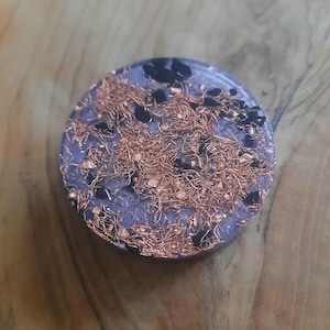 May include: A round, purple and black resin coaster with gold flecks.