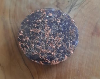 Può includere: Un sottobicchiere rotondo in resina di colore viola scuro e rame con una finitura scintillante.