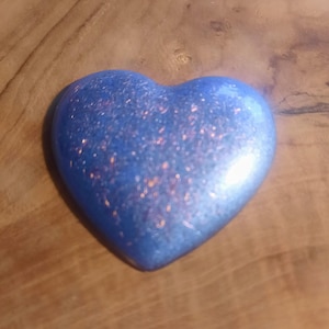 May include: A blue heart-shaped resin paperweight with a glittery finish.