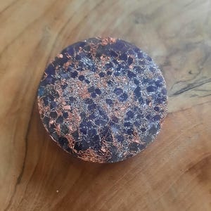 May include: A round, dark purple and silver crystal with copper wire and glitter embedded in the resin.
