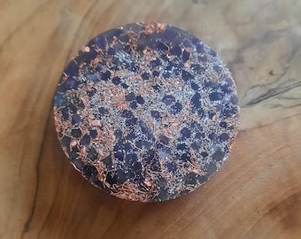 Può includere: Un cristallo rotondo di colore viola scuro e argento con filo di rame e glitter incorporati nella resina.