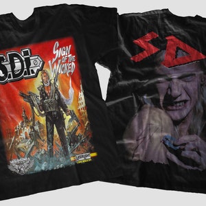 May include: Black t-shirt with a graphic print of a man holding a gun and the text "Sign of the Wicked" and "SDI". The back of the shirt has a red graphic print of the text "SDI" and a man's face.