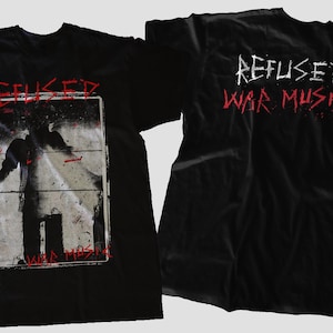 Puede incluir: Camiseta negra con un estampado gráfico rojo de la banda Refused. La parte delantera de la camiseta presenta una foto de una persona frente a una pared con el texto "War Music" debajo. La parte trasera de la camiseta tiene el texto "Refused War Music" en rojo.