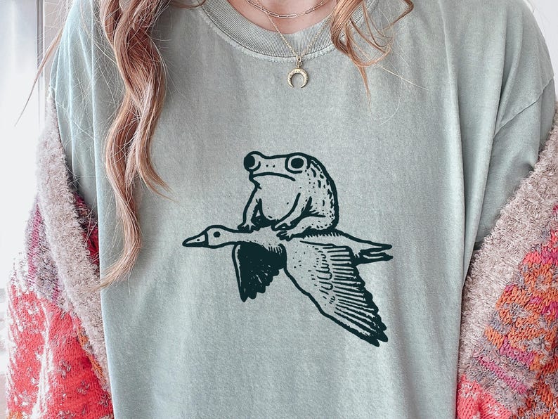 Seltsames Frosch- und Gans-Shirt - schrulliges Tier-wunderliches Geschenk-T-Stück - Kröten-Reitgans-T - Lustiges Tier-T-Shirt - Meme-T-Stück Bay