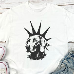 Op de afbeelding: Een wit t-shirt met korte mouwen en een zwarte grafische print van een hond met een stekelige hanenkam en een halsband met stekels. De hond is in profiel afgebeeld met gedetailleerde schaduwen, gecentreerd op de voorzijde van het kledingstuk.