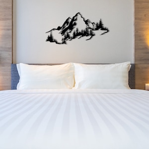 May include: A white bed with a white duvet cover and two white pillows. The bed is in a bedroom with a wooden headboard and a black metal wall sculpture of a mountain range with trees.