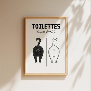 K&ouml;nnte beinhalten: Gerahmter Kunstdruck mit dem Wort "TOILETTES" &uuml;ber dem Text "Ouvert 24h24". Der Druck zeigt zwei stilisierte R&uuml;ckansichten von Katzen, eine schwarze und eine wei&szlig;e, getrennt durch eine vertikale Linie. Die Kunst ist in einem Holzrahmen.