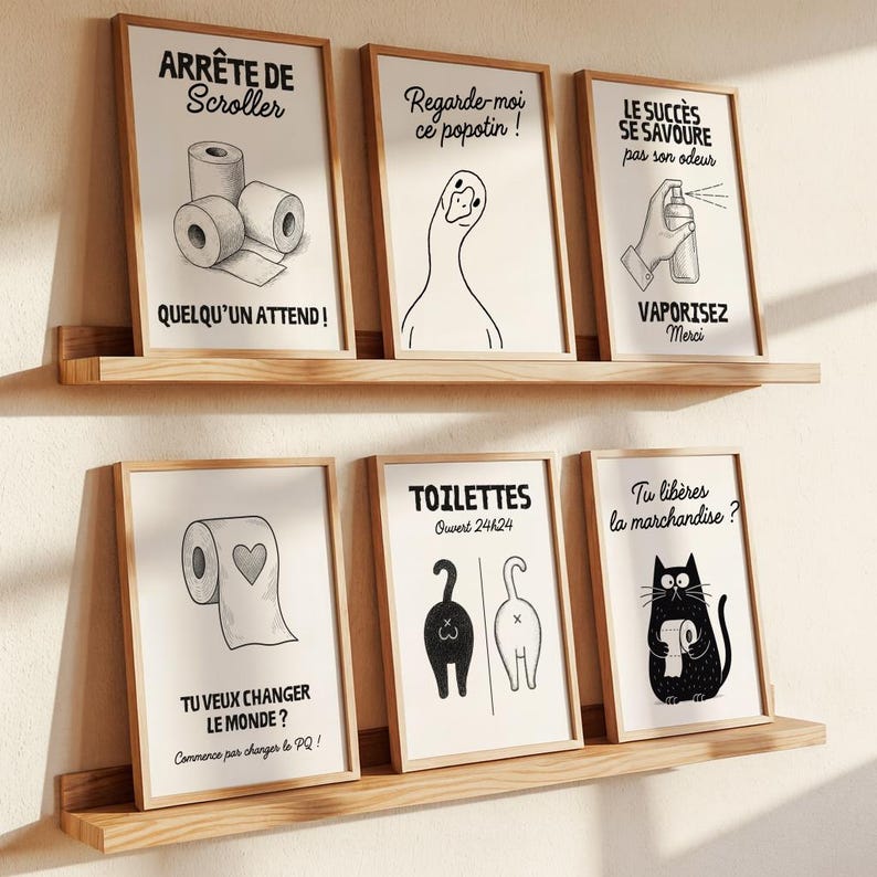 K&ouml;nnte beinhalten: Sechs gerahmte Kunstdrucke mit humorvollen Illustrationen zum Thema Badezimmer und Text. Die Drucke werden auf Holzregalen ausgestellt. Die Illustrationen umfassen Toilettenpapierrollen, eine Gans, eine Hand, die Lufterfrischer spr&uuml;ht, und eine Katze mit Toilettenpapier.