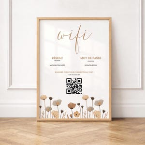 Peut inclure: Un cadre en bois avec le mot "wifi" en écriture élégante. Il affiche les détails du réseau et du mot de passe, ainsi qu'un code QR pour un accès facile. Le bas présente un motif floral aux tons neutres.