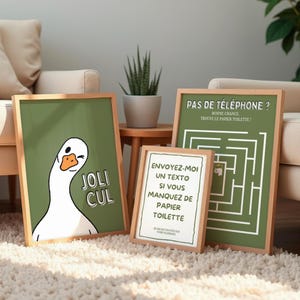 Peut inclure: Trois impressions encadrées avec des cadres en bois. L'une présente une oie qui fait un clin d'œil avec le texte "JOLI CUL". Une autre a un labyrinthe et le texte "PAS DE TÉLÉPHONE? BONNE CHANCE TROUVE LE PAPIER TOILETTE!". La troisième dit "ENVOYEZ-MOI UN TEXTO SI VOUS MANQUEZ DE PAPIER TOILETTE".