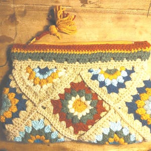 Crochet pouch, lined with cotton Orange zip and pompom. Cotton interior printed with seventies flowers