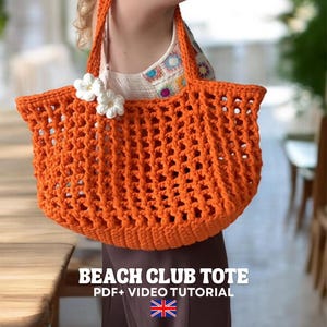 May include: A bright orange crochet tote bag with an open-work mesh pattern and two sturdy handles. Two white crocheted flowers are attached to the upper left side. The text BEACH CLUB TOTE PDF+ VIDEO TUTORIAL is displayed below the bag.
