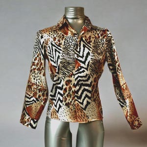 Pode incluir: Camisa de manga comprida com uma estampa animal arrojada. A camisa apresenta uma mistura de estampas de leopardo, zebra e outros animais em tons de castanho, preto e creme. A camisa é exibida em um manequim.
