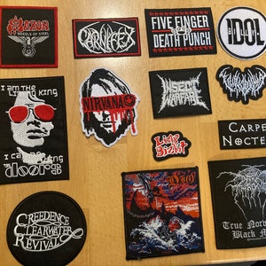 Könnte beinhalten: Eine Sammlung von 12 gestickten Bügelbildern mit verschiedenen Musikbands, darunter Saxon, Carnifex, Five Finger Death Punch, Idol, Nirvana, Insect Warfare, Limp Bizkit, Carpe Noctem, Creedence Clearwater Revival und True Norwegian Black Metal.