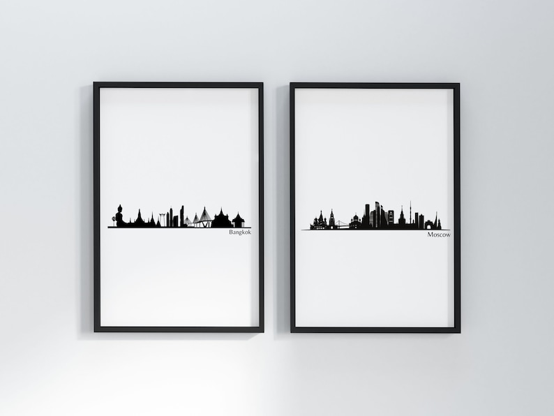 May include: Two black and white framed prints of city skylines. The left print shows the Bangkok skyline with the text "Bangkok" below. The right print shows the Moscow skyline with the text "Moscow" below.