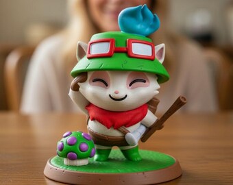 May include: A figurine of a cartoon character with a green hat, red goggles, and a red scarf. The character is holding a wooden staff and standing on a green base with a mushroom. The figurine is on a wooden table.