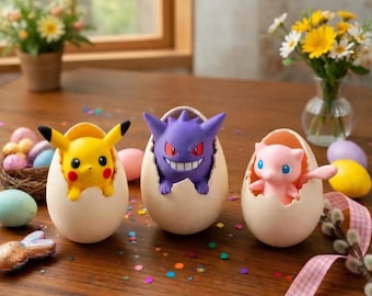 May include: Three Pokémon figures emerge from eggshell-shaped containers. A yellow Pikachu, a purple Gengar, and a pink Mew are featured. The scene is set on a wooden table with Easter eggs and flowers in the background.