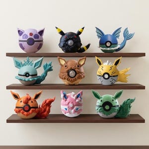 May include: Nine colourful, spherical figurines with animal-like features are displayed on three wooden shelves. The figurines are in various colours, including purple, black, blue, brown, yellow, orange, pink, and green. Each has unique details.